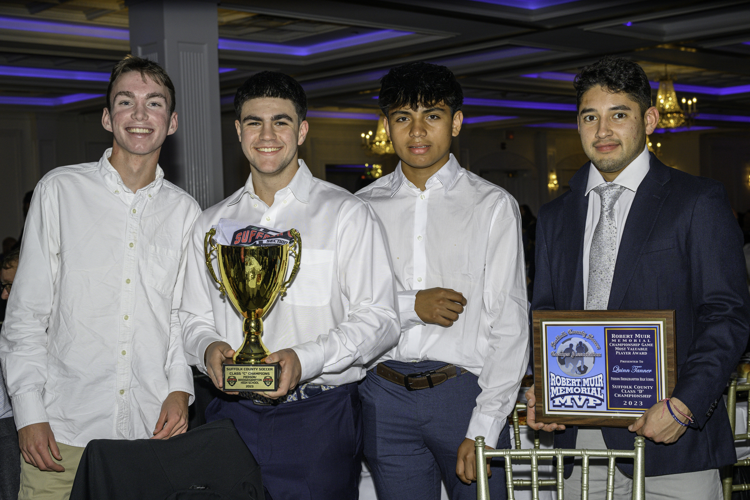 Wilmer Reyes, Ryder Esposito and Augustus Hayes with the Pierson/Bridgehampton boys soccer Suffolk County Class C Championship trophy and head coach Luis Aguilar with the MVP trophy for Quinn Tanner.  MARIANNE BARNETT