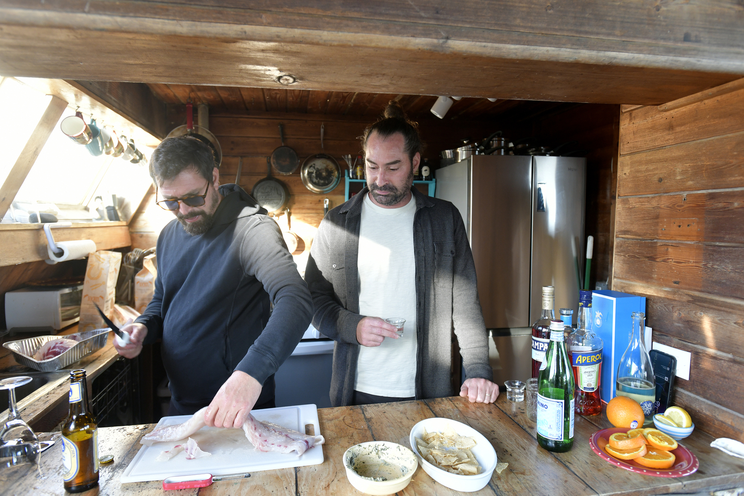 Matt Frisbie, right, with his brother Orson at work on the meal in the kitchen.  DANA SHAW