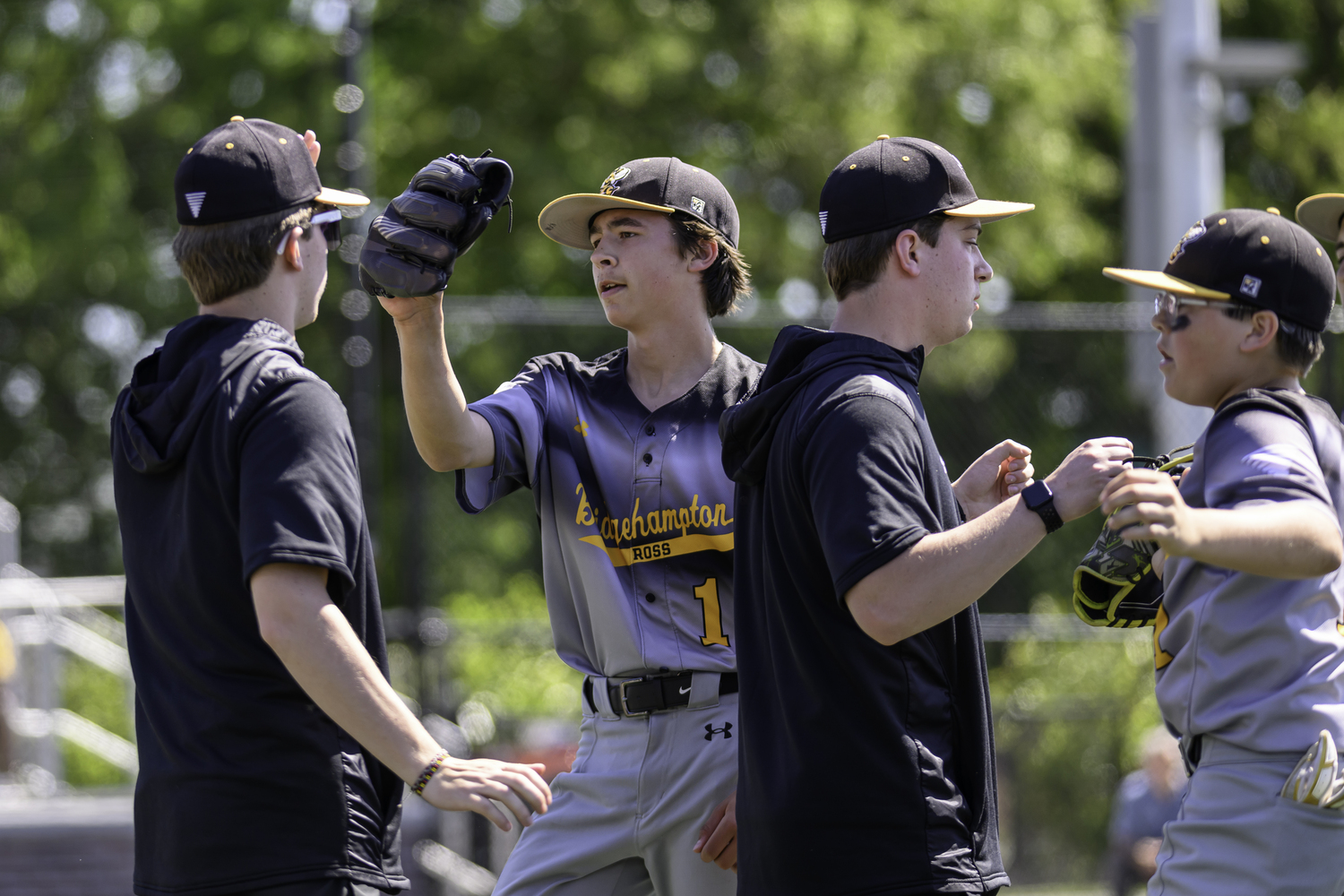 Bridgehampton brothers Kai and Finn Alversa are congratulated by former Killer Bees Kris and Scott Vinski after an inning. MARIANNE BARNETT