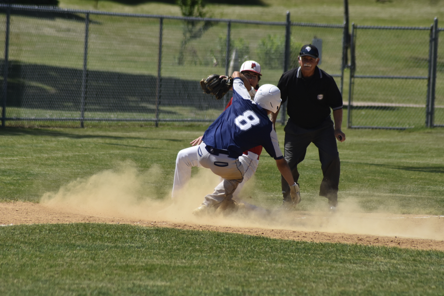 Pierson third baseman Charles Schaefer tags out a Burke Catholic player trying to steal third base.   DREW BUDD