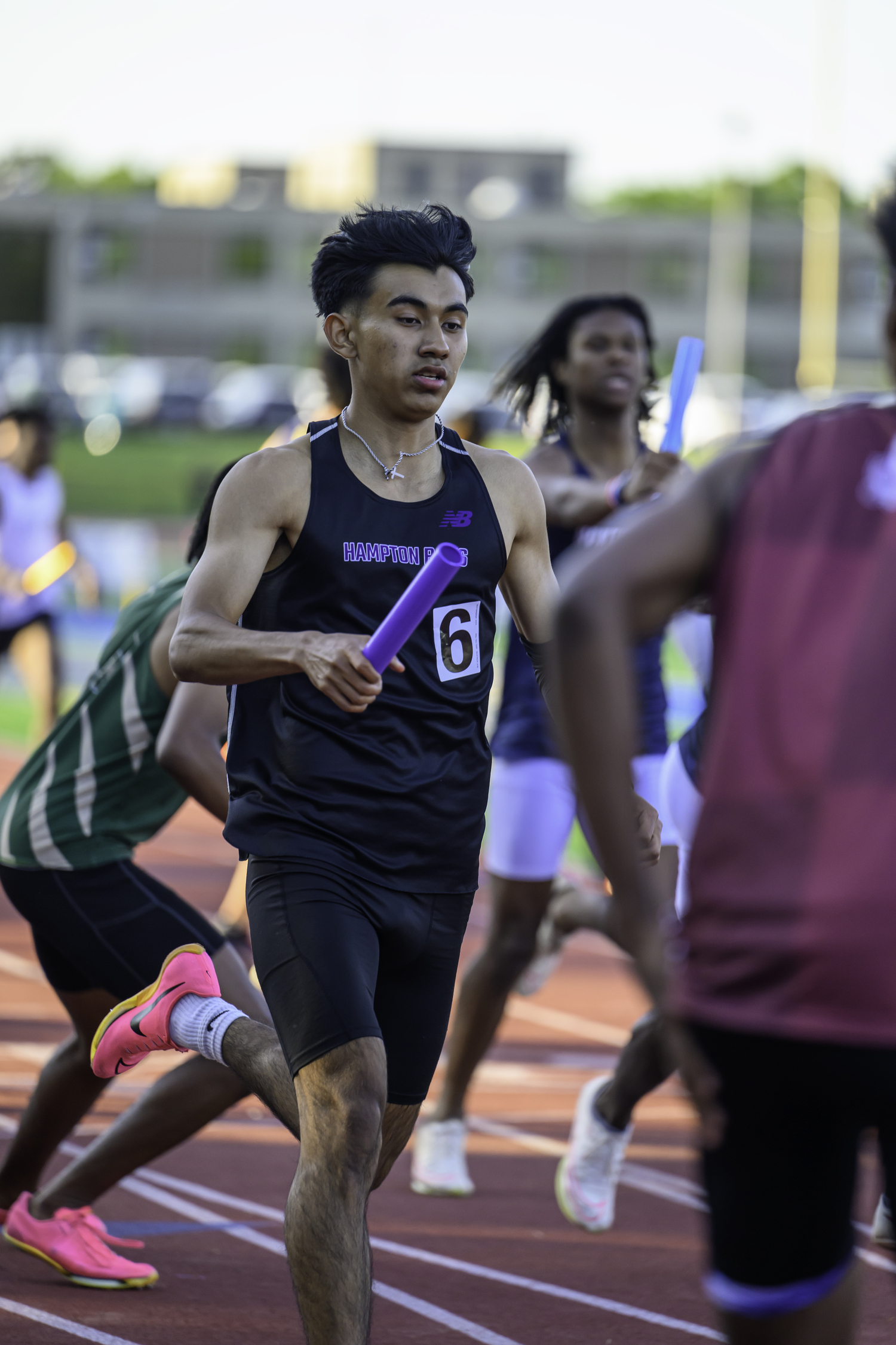 Charlie Garcia reaches out with the baton in the 4x400-meter relay.   MARIANNE BARNETT