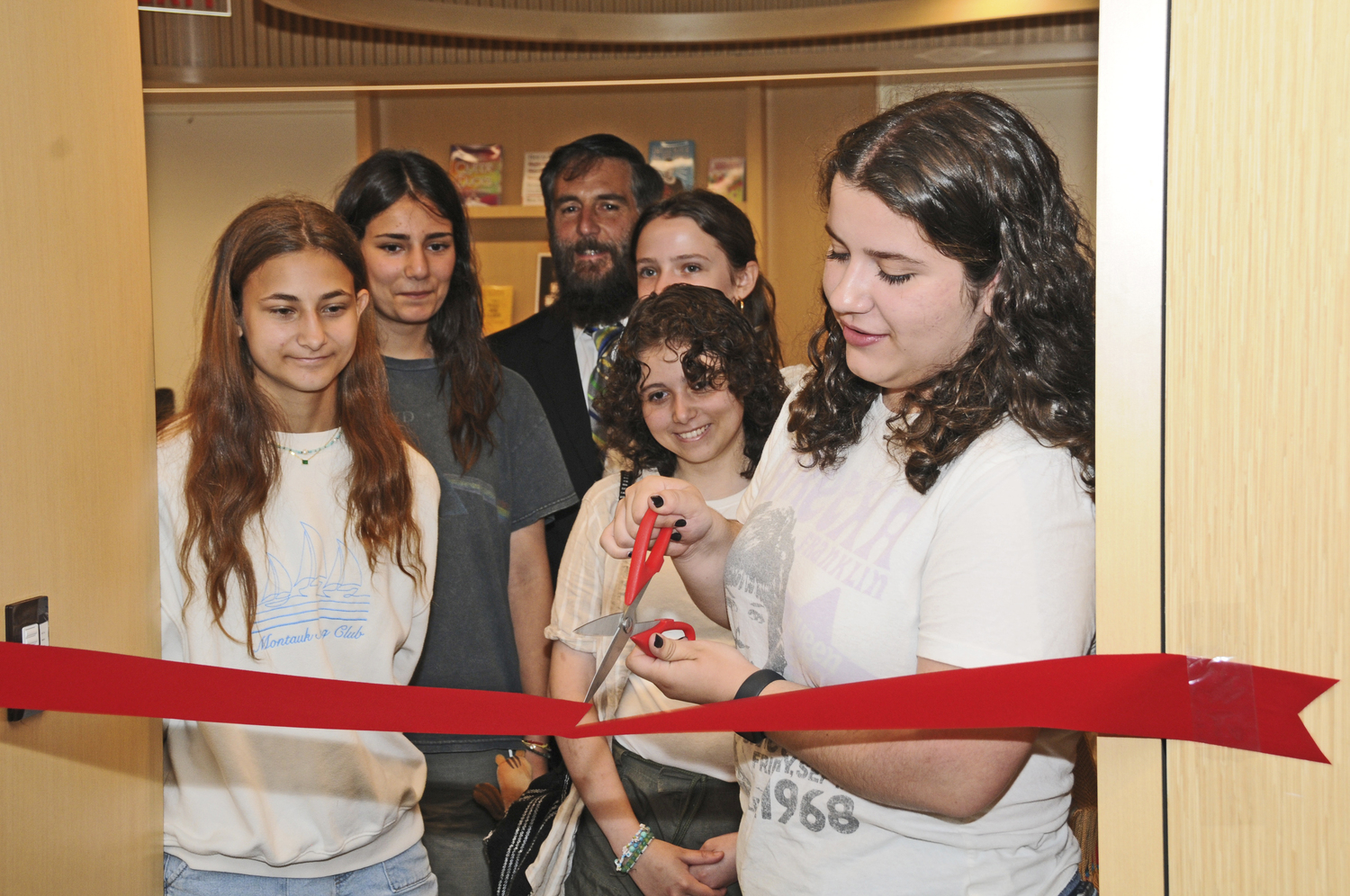 Mary Jo Corron, artist Shanli Yaghoubi, East Hampton Library Director Dennis Fabiszak, artist Cybelle Curry, Gray Guzman and Sophia Rodriguez cut the ribbon opening the new Young Adult Room  at the East Hampton Library, which includes a recording/podcast studio.   RICHARD LEWIN