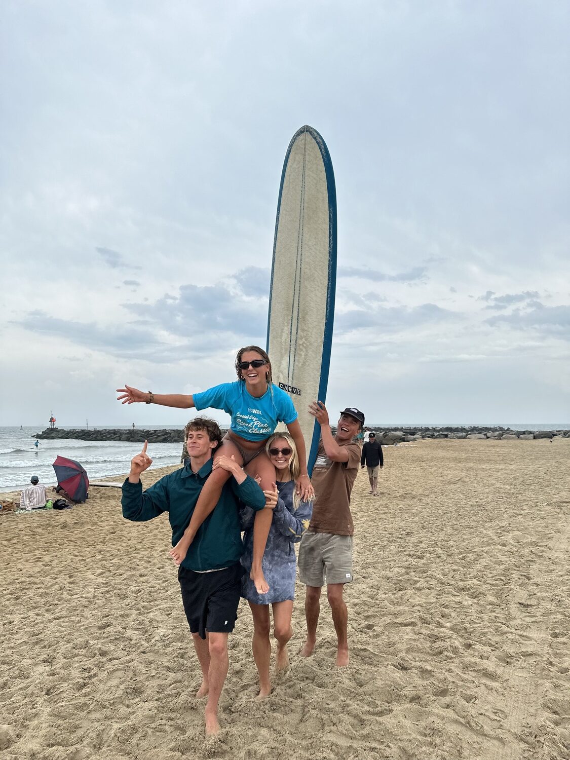 Chloe Coleman celebrates her victory with brother Tucker Coleman, left, and friends Indie Hoffman and Greyson Messier (holding board).