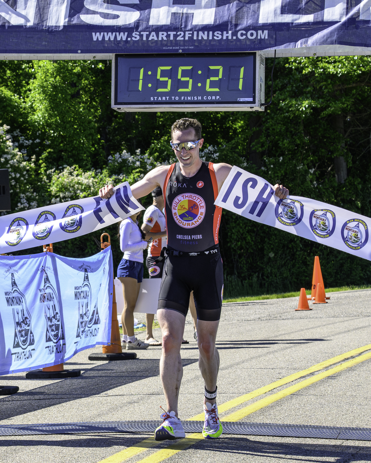 William Huffman rips apart the finish line tape as the overall champion of the full triathlon.  MARIANNE BARNETT