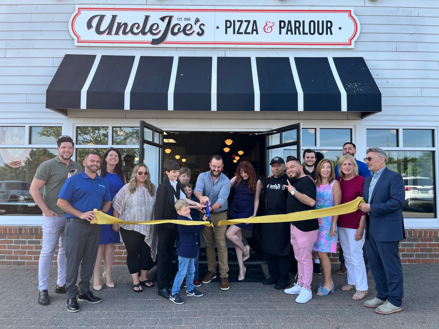 Members of the Hampton Bays Chamber of Commerce celebrate the opening of Uncle Joe’s Pizza & Parlour in Hampton Bays during a ribbon-cutting ceremony on June 4. KEITH SCHULTZ